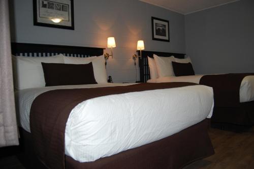 a hotel room with two beds and two lamps at Rest Inn in Terrace