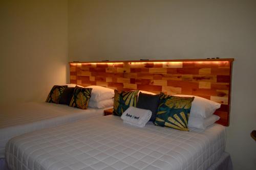 a bedroom with two beds and a wooden headboard at Casa Ana, Flores Island in Flores