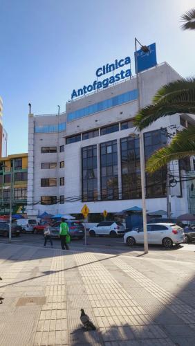 a building with cars parked in a parking lot at Departamento Centro Sur 1 Dormitorio 1 baño Full equipado in Antofagasta