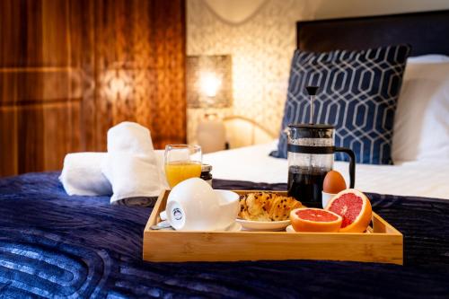 a tray of food on top of a bed at QF Living Apartments in Caister-on-Sea