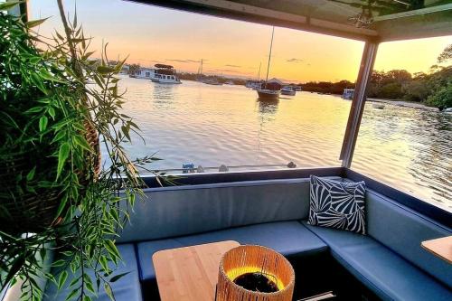 a bench in a boat with a view of the water at Liquid Spirit Noosaville houseboat " EXPERIENCE MORE " in Noosa Heads