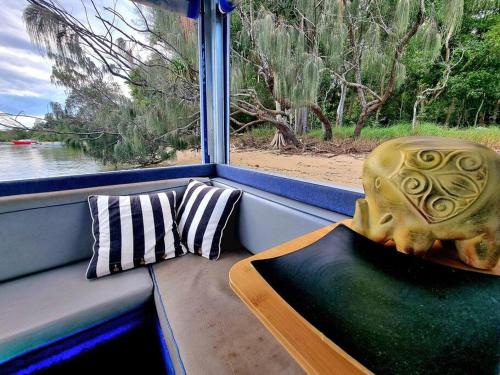 a window seat with a skull statue and a pillow at Liquid Spirit Noosaville houseboat " EXPERIENCE MORE " in Noosa Heads