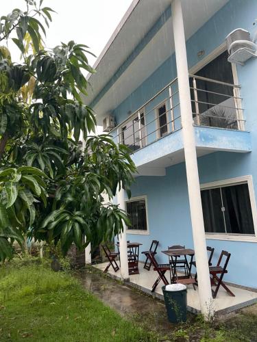 een blauw huis met een tafel en een balkon bij Villa Rainer in Porto Seguro
