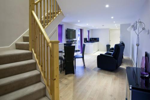a living room with a staircase and a dining room at QF Living Apartments in Caister-on-Sea