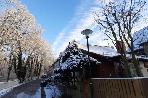 a house covered in snow next to a fence at Kleines Ferienhaus Hoher Stein im Elbtal in Coswig