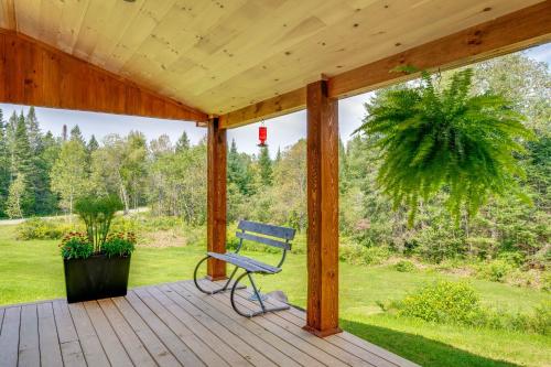 a blue chair sitting on a wooden porch at Fire Pit and Views Pet-Friendly Vermont Cabin in Craftsbury