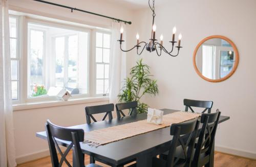 a dining room with a black table and chairs at Annapolis Charm Waterfront Getaway Near USNA - FISH & CRAB from your PRIVATE PIER! in Annapolis