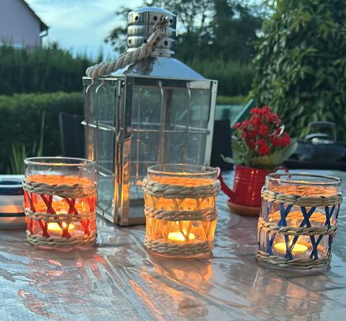 une table avec trois pivots en verre et une lanterne dans l'établissement maison privée offre chambre hôte, à Kingersheim