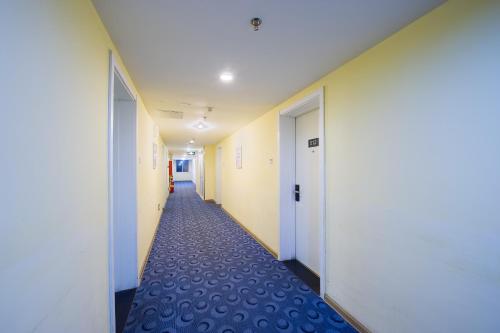 a hallway of an office with white walls and blue carpet at 7Days Inn Chengdu Wuda Garden in Chengdu