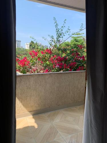 a window view of a garden with pink flowers at Pousada Ohana Rj in Rio de Janeiro
