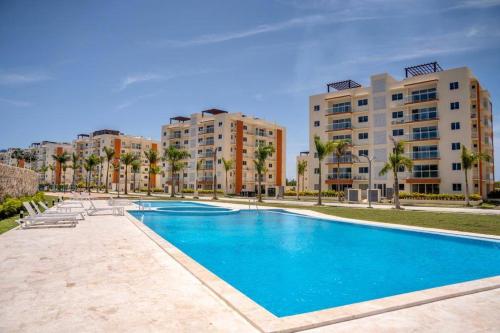 a large swimming pool with buildings in the background at Pool Sensation Punta Cana in Bávaro