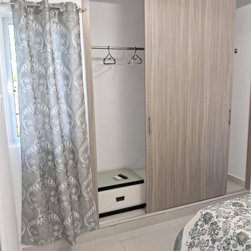 a bedroom with a bed and a cabinet with a mirror at Pool Sensation Punta Cana in Bávaro