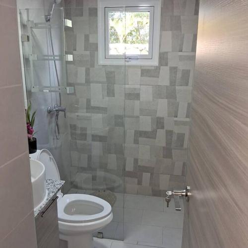 a bathroom with a toilet and a sink and a window at Pool Sensation Punta Cana in Bávaro