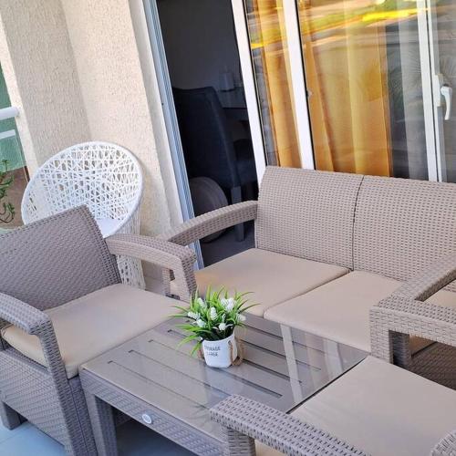 a porch with wicker chairs and a table with a plant at Pool Sensation Punta Cana in Bávaro