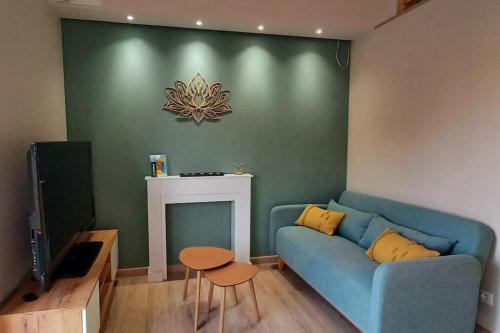 a living room with a blue couch and a fireplace at La Cabane de Shakespeare mini-maison à Haguenau in Haguenau