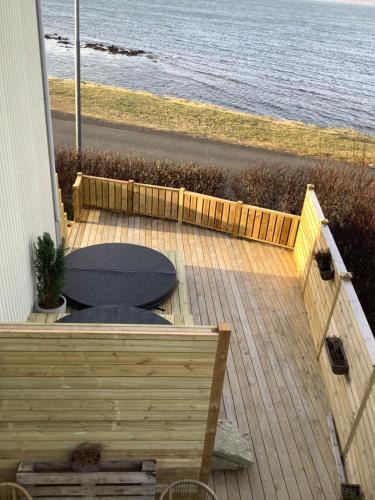 a wooden deck with a toilet on the beach at The Castle in Búðardalur