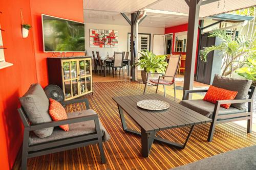 a living room with a table and chairs at Villa élégante avec jardin au Lamentin et piscine privée. in Le Lamentin