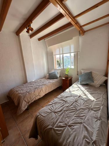 a bedroom with two beds and a window at Blue Home in Los Alcázares