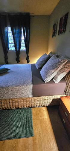 a bedroom with a bed with pillows and a window at Villa élégante avec jardin au Lamentin et piscine privée. in Le Lamentin