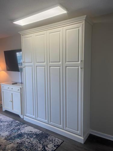 a white closet in a room with a television at Summer Sands - 304 by Sea Scape Properties in Wrightsville Beach