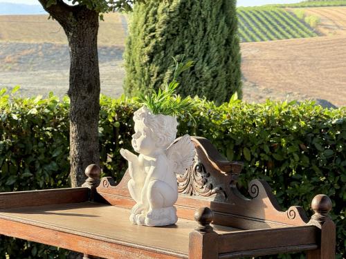 a white statue sitting on top of a wooden bench at Agriturismo Il Raduno - Max Lelli in Marsiliana