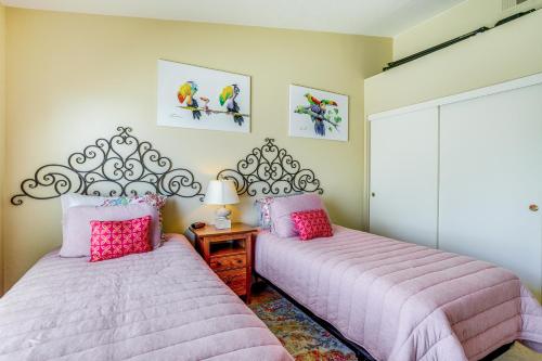 two beds in a bedroom with pink sheets at Near Golf Condo with Pool Access in Palm Desert! in Palm Desert