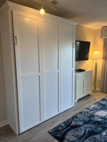 a large white closet in a room with a television at Summer Sands - 307 by Sea Scape Properties in Wrightsville Beach