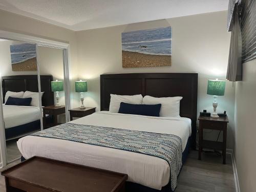 a hotel room with a bed and two windows at Summer Sands - 308 by Sea Scape Properties in Wrightsville Beach
