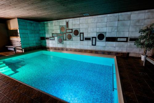 a swimming pool with blue water in a building at Gasthof Zinkenbachmühle in Sankt Gilgen