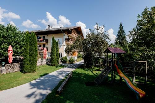 a playground in a yard with a house at Gasthof Zinkenbachmühle in Sankt Gilgen