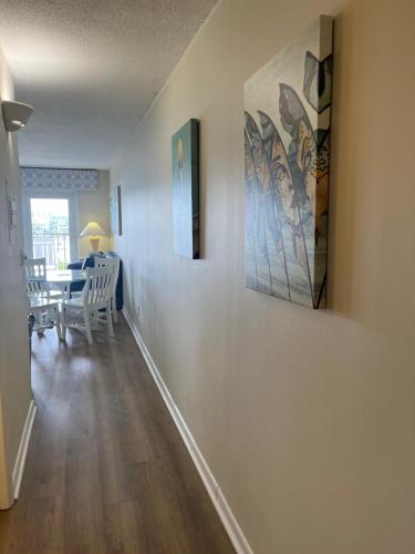 a dining room with a table and a painting on the wall at Summer Sands - 401 by Sea Scape Properties in Wrightsville Beach