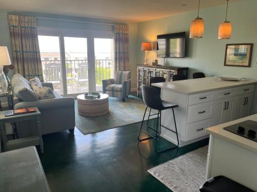 a living room with a couch and a table at Summer Sands - 406 by Sea Scape Properties in Wrightsville Beach