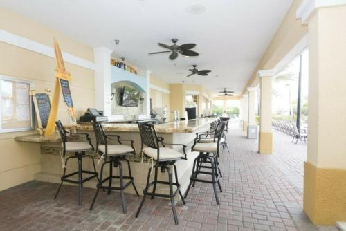 a bar with stools in the middle of a restaurant at Modern Vacation Apartment with a Lake View in Orlando
