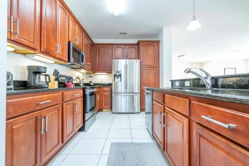 a kitchen with wooden cabinets and a stainless steel refrigerator at Wonderful Apt Convention Center VistaCay VC50253 in Orlando