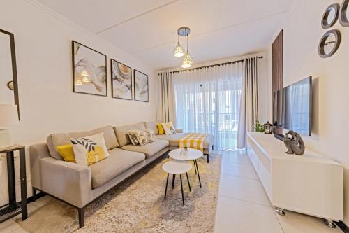 a living room with a couch and a tv at Bloom Modern Apartment in Fourways