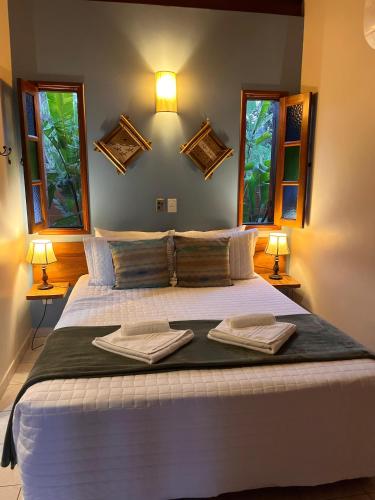 a bedroom with a large bed with two towels on it at Pousada Recanto da Grande Paz in Alto Paraíso de Goiás