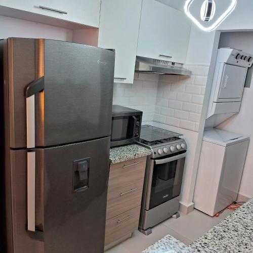 a kitchen with a stainless steel refrigerator and a microwave at Pool Sensation Punta Cana in Bávaro