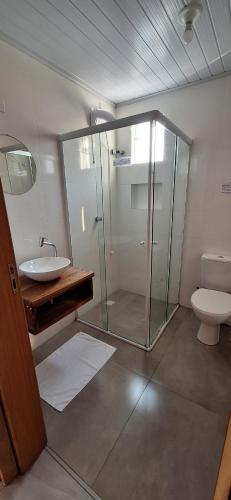 un bagno con doccia in vetro e WC di Quarto Privativo poucos minutos da Vila Germânica Oktoberfest a Blumenau