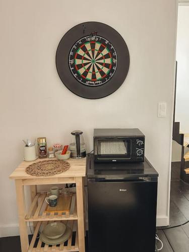 a dart board hanging on a wall next to a microwave at Loft room heerenhuys in Eeklo