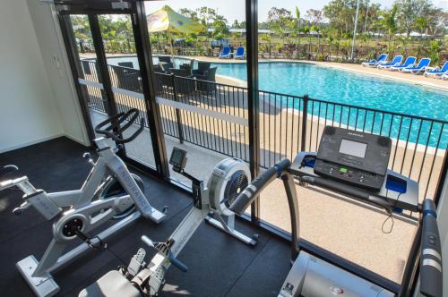 a fitness room with a gym with a swimming pool at Quality Resort Parkhurst in Rockhampton