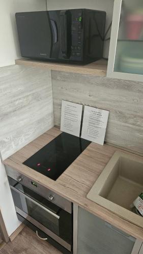 a kitchen with a counter with a microwave and a sink at Apartman RELAX in Trenčín