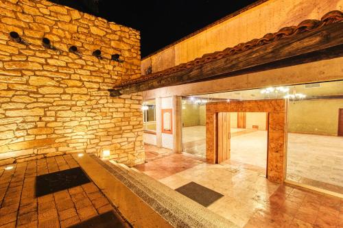 an empty room with a stone wall and a doorway at Hotel Ciudad Real Palenque in Palenque
