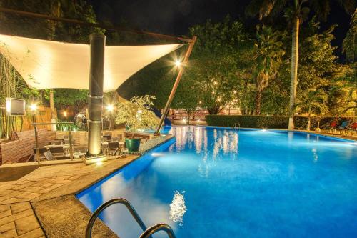 a large swimming pool at night with lights at Hotel Ciudad Real Palenque in Palenque