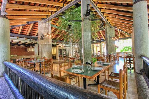 a dining room with tables and chairs in a building at Hotel Ciudad Real Palenque in Palenque