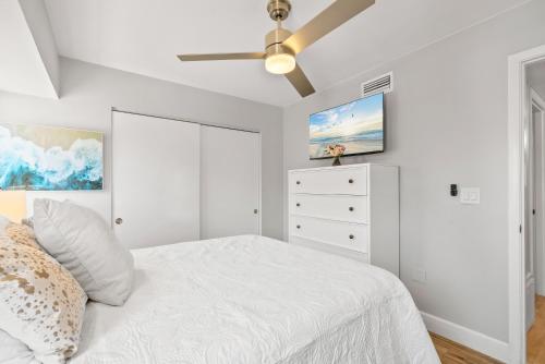 a bedroom with a white bed and a ceiling fan at Beach Rd, 300ft to Beach Access & 500ft to Siesta Key Village, 2bdr & Studio in Siesta Key