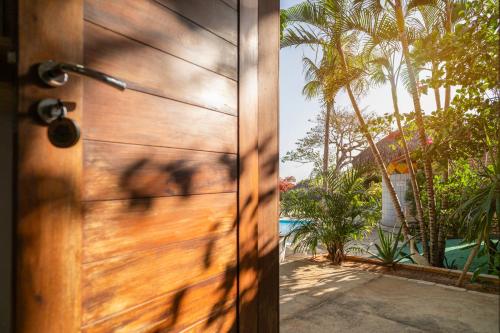 a wooden door with a view of a pool at Casa Suiça Brasileira in Jericoacoara