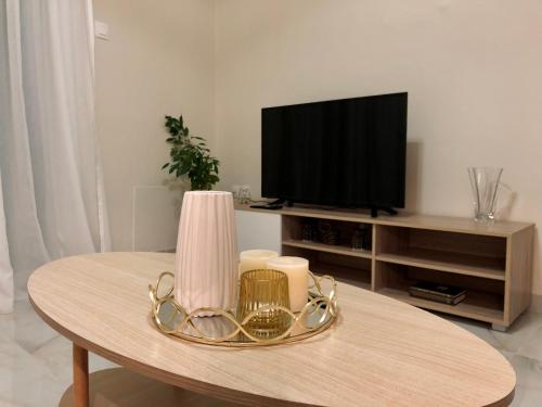 ein Wohnzimmer mit Tisch und Fernseher in der Unterkunft Eva's Sweet Home in Thessaloniki