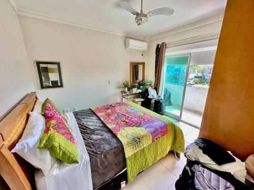 a bedroom with a bed and a sliding glass door at Verão de Luxo no Condomínio Condado de Capão in Capão da Canoa