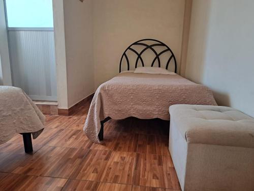 a bedroom with two beds and a wooden floor at Hostal Edén in Torotoro