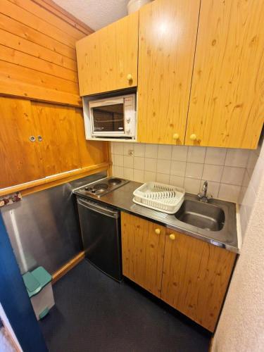 une petite cuisine avec un évier et un micro-ondes dans l'établissement Résidence Le Thabor - studio 4 personnes en plein coeur station 19m² MAE-2965, à Modane